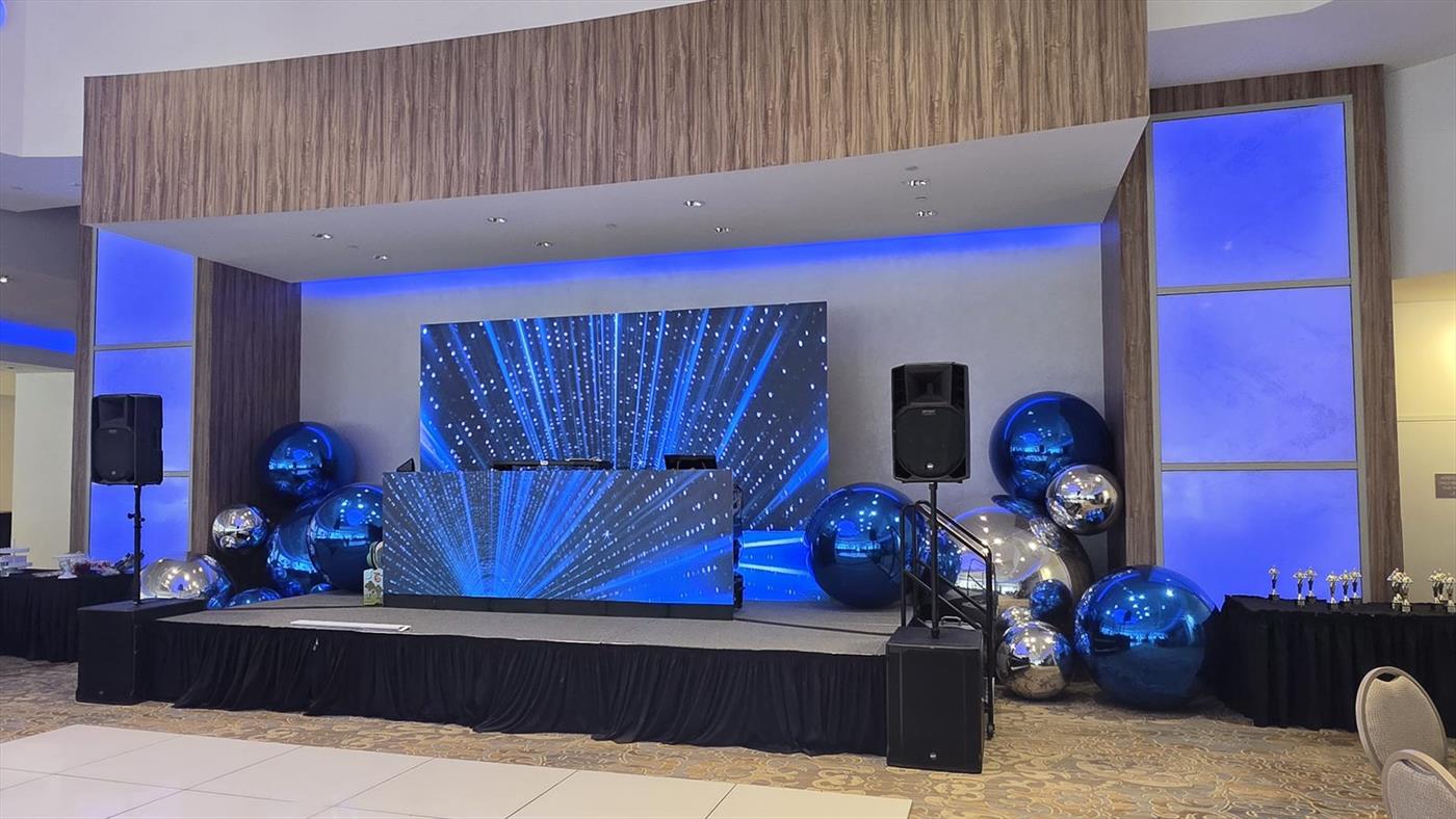 A skirted stage deck carrying an LED video wall and an LED DJ booth