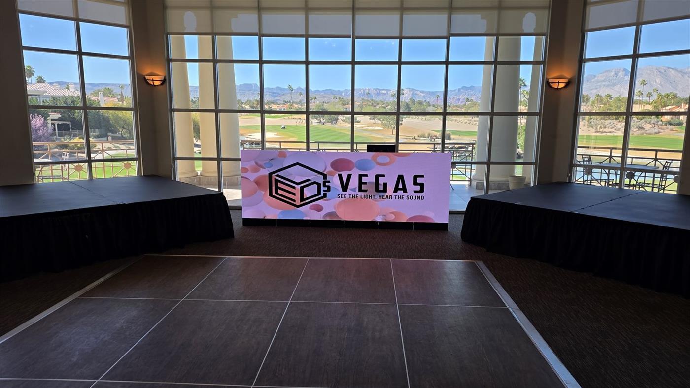 An LED DJ booth between two skirted stage decks
