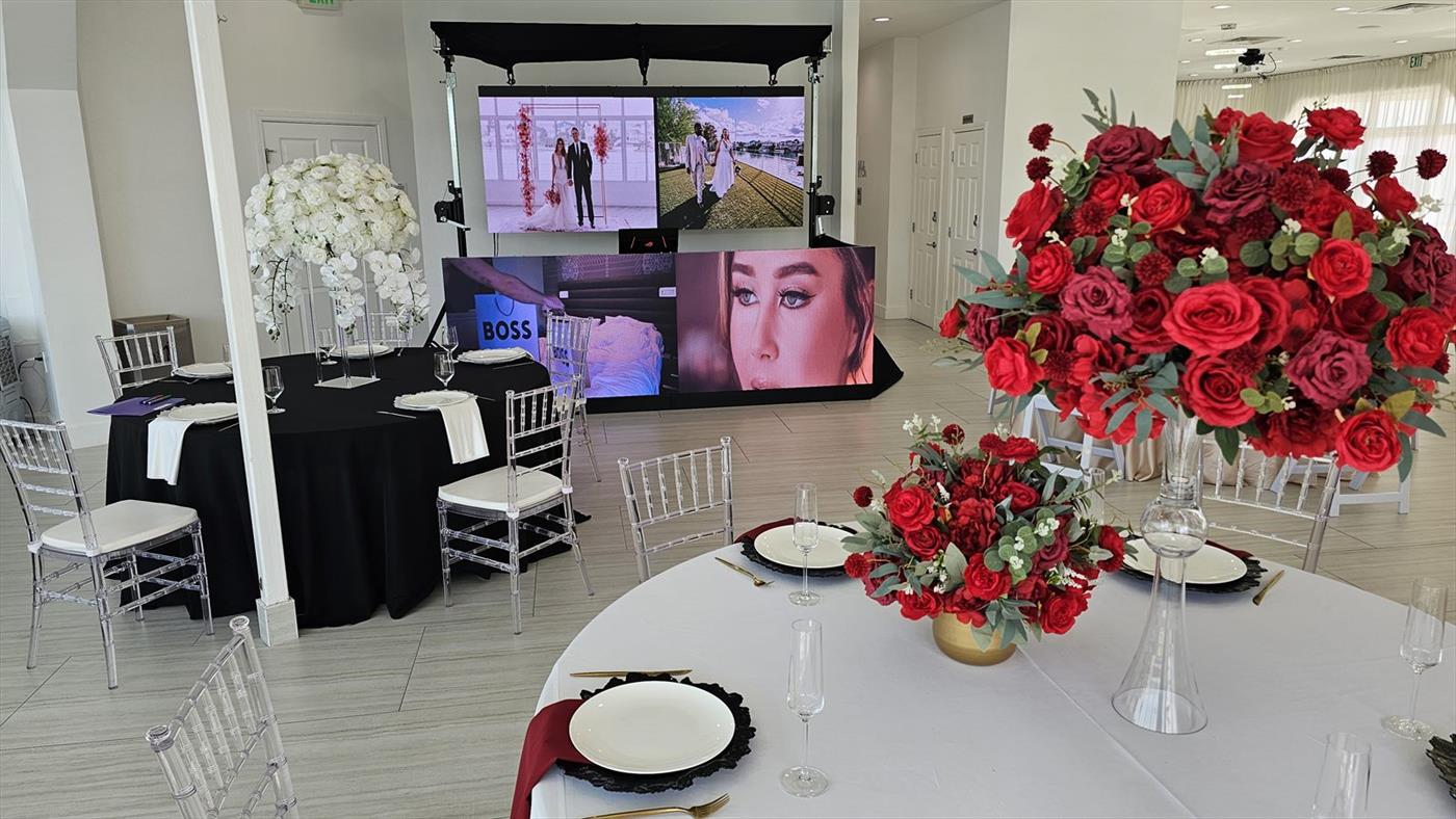 Two LED video walls behind the head table at a wedding reception